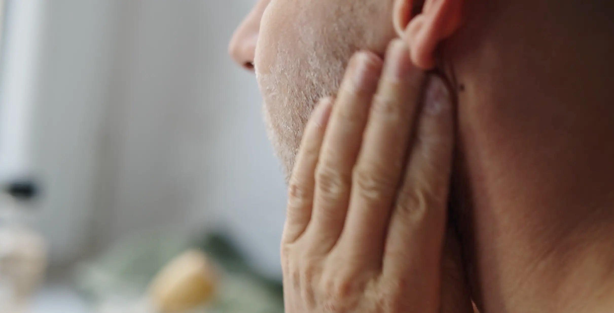 man rubbing cream face beard